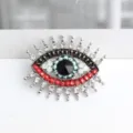 Close-up detail van vintage Boze Oog strass broche, sprankelend kristalontwerp voor vrouwen. - Zilver