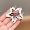 Detailed shot of white star-shaped leather hair clip with black dots and metal snap clip. - Five-Pointed Star Polka Dot / White