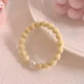 Cute yellow bean hair tie with white pearl charm elastic ponytail holder for daily styling. - Pearl Yellow