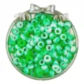 Close-up of green and white marbled pony barrel beads in decorative silver bow tray for DIY crafts. - Green