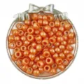 Primo piano di perline a barilotto arancioni perlate per treccine e creazione di gioielli fai-da-te. - Arancione