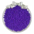 Close-up of vibrant purple glass seed beads neatly displayed in a decorative silver tray. - Deep purple