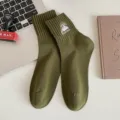 Mens army green cotton crew socks featuring mountain embroidery flat lay lifestyle shot - One Size / Army Green