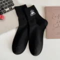 Men's black crew socks featuring stylish mountain embroidery, comfortable cotton athletic socks. - One Size / Black