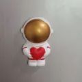 Detaillierte Nahaufnahme einer niedlichen Astronautenfigur mit rotem Herz als Harzdekor. - Hände Halten Rotes Herz Stil (1365)