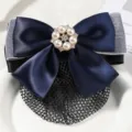 Detailed close-up of a navy blue bow hair net clip with pearl rhinestone center and mesh. - White Yarn Large Pearl Fine Mesh / Blue