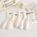 Gros plan de belles chaussettes mi-hautes en coton blanc avec de jolies broderies. - Taille unique / Ours en peluche / Blanc