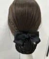 Close-up of a black satin hair bow with net bun cover, elegant professional hair accessory. - Small Label Coarse Net / Black