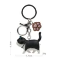 Niedlicher schwarz-weißer Katzen-Schlüsselanhänger mit Pfoten-Anhänger und Metallverschluss. - Karabiner-Stil / Schwarz-Weiße Katze (Braune Kralle)