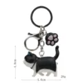 Niedlicher schwarz-weißer dicker Katzen-Schlüsselanhänger mit Pfoten-Anhänger. - Karabiner-Stil / Schwarz-Weiße Katze (Schwarze Katzenkralle)