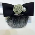 Detailed view of black fabric bow hair clip with green satin rose, pearl and mesh net. - Bud Elegant Green Fine Mesh