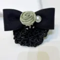 Detailed close-up of elegant black hair net bow with sage green satin rose and pearl detail. - Bud Elegant Green Coarse Mesh