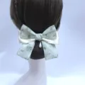 Detail view of elegant green lace hair bow with pearl pendant, professional hairnet bun cover. - Pendant Style / Coarse Net / Green Forest