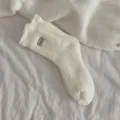 Close up detail of embroidered sweet wool-blend cozy mid-calf socks in classic white color for daily wear - 35-40 / Off White