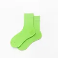 Detailaufnahme der leuchtend hellgrünen Baumwollsocken in der Nahaufnahme, weiche Textur. - Einheitsgröße / Fluoreszierendes Grün