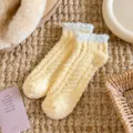 Détail de chaussettes duveteuses en corail, points en silicone antidérapants, confort hiver. - Anti-Perte de Poils / Jaune
