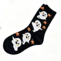 Detail view of black fuzzy plush Halloween socks featuring cute white ghost and orange star. - Size 35-40 / Black