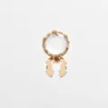 Close-up detail of golden crystal rhinestone shirt cufflink and decorative button accessory. - Gold-Rhinestone