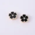 Gros plan détail de luxe des boutons de manchette en métal fleur strass émail noir. - Noir
