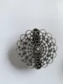 Detailed shot of vintage silver filigree round floral shawl clip scarf buckle accessory. - Style 1