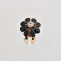 Dettaglio in primo piano dell'elegante bottone spilla a fiore in cristallo nero. - Nero