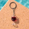 Close-up of miniature red wine glass keychain on stone background - Wine Glass