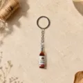 Close-up of miniature wine bottle keychain charm on elegant textured background - Wine Bottle