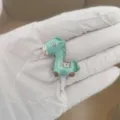 Detail view of a cute green horse 3.5mm dust plug phone accessory, resin material. - Fortune Horse / Green