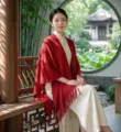 Elegant red knitted shawl detail, vintage fringe design for women in traditional garden. - Ussuri Hollow Shawl / Burgundy