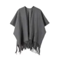 Gros plan sur les détails du poncho en tricot gris foncé à franges, texture chaude douce. - Gris