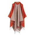 Detailed view of the women's stylish knitted hooded poncho with fringe and dual-color design. - Orange