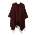 Gros plan détaillé de la cape poncho en tricot à franges avec bouton et ourlet. - Bordeaux