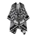 Nahaufnahme des schwarz-weißen Hahnentritt-Strickponchos mit ethnischen geometrischen Mustern. - Schwarz