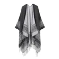 Detailansicht des schwarzgrauen geometrischen Strickponchos mit Fransen am Saum. - Schwarz