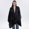 Detailaufnahme des eleganten schwarz-grauen Strick-Capes mit retro-künstlerischen Mustern. - Fashion - Schwarzgrau