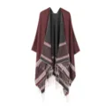 Close-up of the geometric patterned hem and fringe details on the knitted cape shawl. - Wine Red