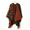 Detailed view of the knit poncho cape featuring a bold orange and green leopard pattern. - Zebra Print Orange