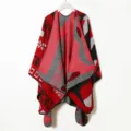 Detailed view of the red and grey knitted poncho with geometric patterns and soft woolen fabric. - Red Cape