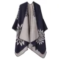 Nahaufnahme des stilvollen Strickponchos mit auffälligem Sonnenblumenmuster und Kontrastfarbdesign. - Sonnenblume - Doppelseitig Marineblau & Hellbeige