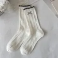Chaussettes mi-hautes blanches tricotées en torsades avec bord volanté et joli nœud variante. - Nœud Papillon Torsadé