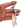 Detailansicht des Yoga Corgi Schlüsselhängers, Hundefigur mit bunten Glocken und Metallring. - Einbeiniger Yoga-Corgi / Rot & Blau