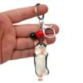 Nahaufnahme des lustigen Yoga-Hund-Schlüsselanhängers mit bunten Glocken für Taschen und Autos. - Einbeiniger Stand Husky / Rot & Schwarz