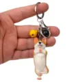Nahaufnahme eines süßen Yoga Corgi Schlüsselanhängers mit Glocke und Metallkarabiner für Tasche. - Einbeiniger Yoga-Corgi / Gelb Schwarz