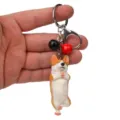 Nahaufnahme des süßen Yoga Corgi Schlüsselanhängers mit Metallkarabiner und Anhängern für Taschen. - Einbeiniger Yoga-Corgi / Rot & Schwarz