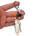 Niedlicher Yoga-Hund Schlüsselanhänger mit Glocken, Metallring und Karabiner für die Tasche. - Einbeiniger Stand Husky / Orange & Schwarz