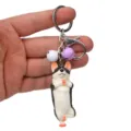 Detailansicht des niedlichen Yoga Hund Schlüsselanhängers mit kleinen Glocken für Taschen. - Einbeiniger Stand Husky / Weiß Lila