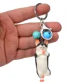 Detailansicht eines niedlichen Yoga Hund Schlüsselanhängers mit Metallring und Glocken. - Einbeiniger Stand Husky / Blau und Hellblau