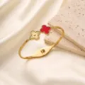 Nahaufnahme des luxuriösen goldenen Kleeblatt-Armbands, roter Emaillierung und feines Muster. - Rotes Kleeblatt Armreif (z291) / Gold