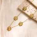 Gros plan détaillé du collier élégant en acier inoxydable fleur de trèfle doré brillant. - Collier Trèfle à Cinq Feuilles / Or