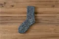 Nahaufnahme von dicken Winter-Melange-Strick-Socken für Herren mit warmer Stoffstruktur. - Einheitsgröße / Schwarz